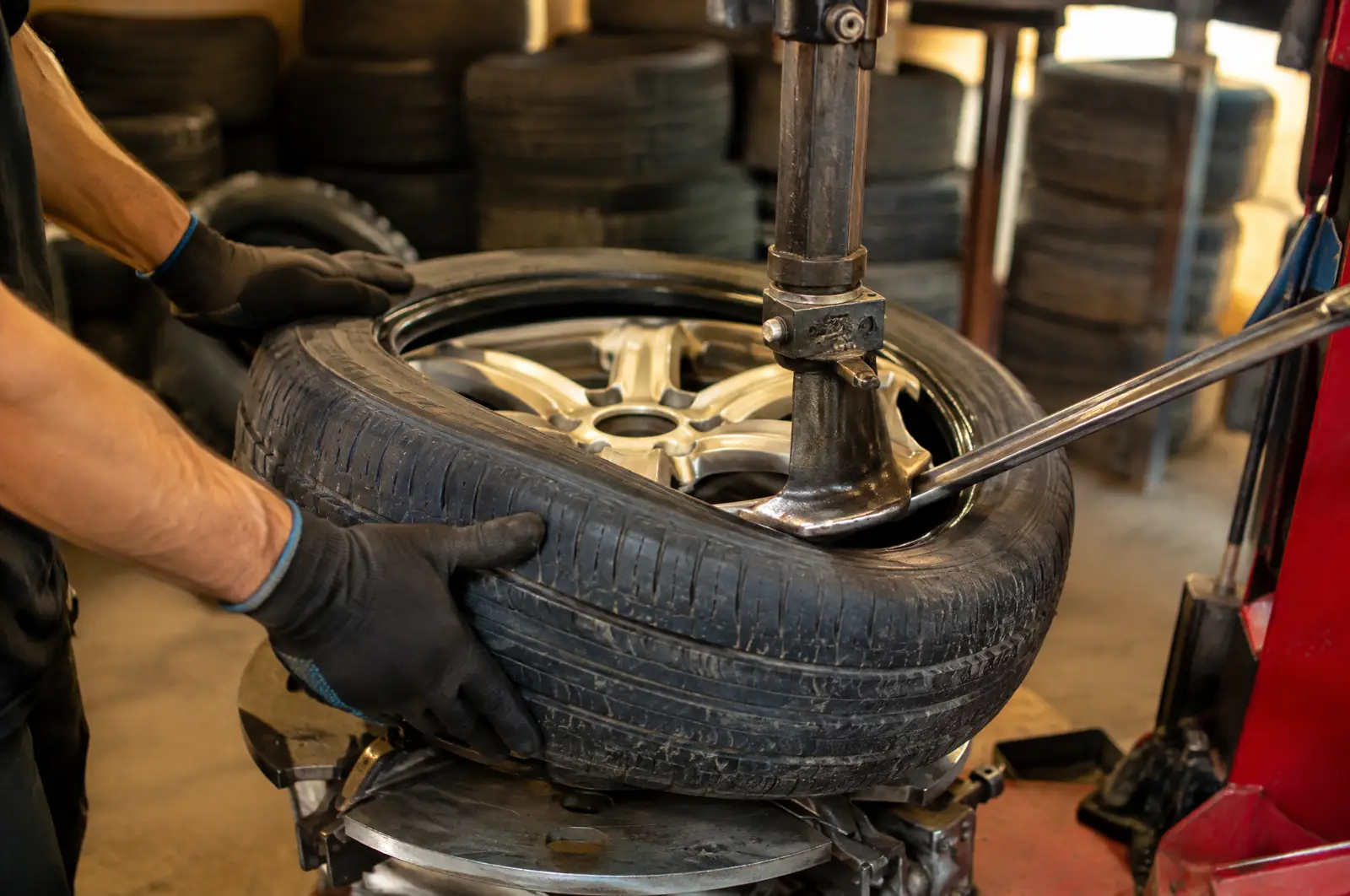 A used tire being seated onto an alloy wheel on a tire changing machine